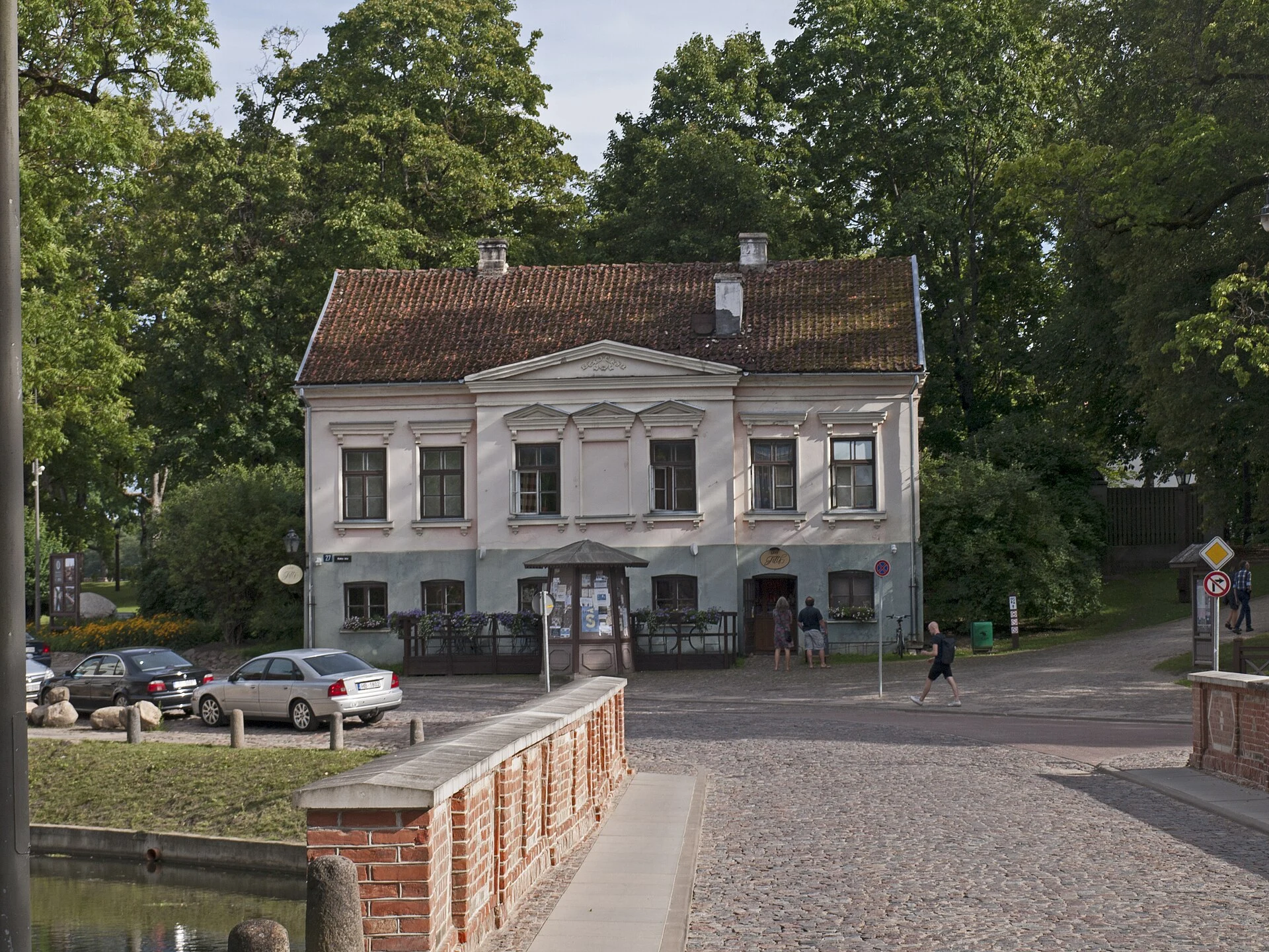 Riacho Alekšupīte junto a edifícios históricos e pequenas pontes em Kuldīga.