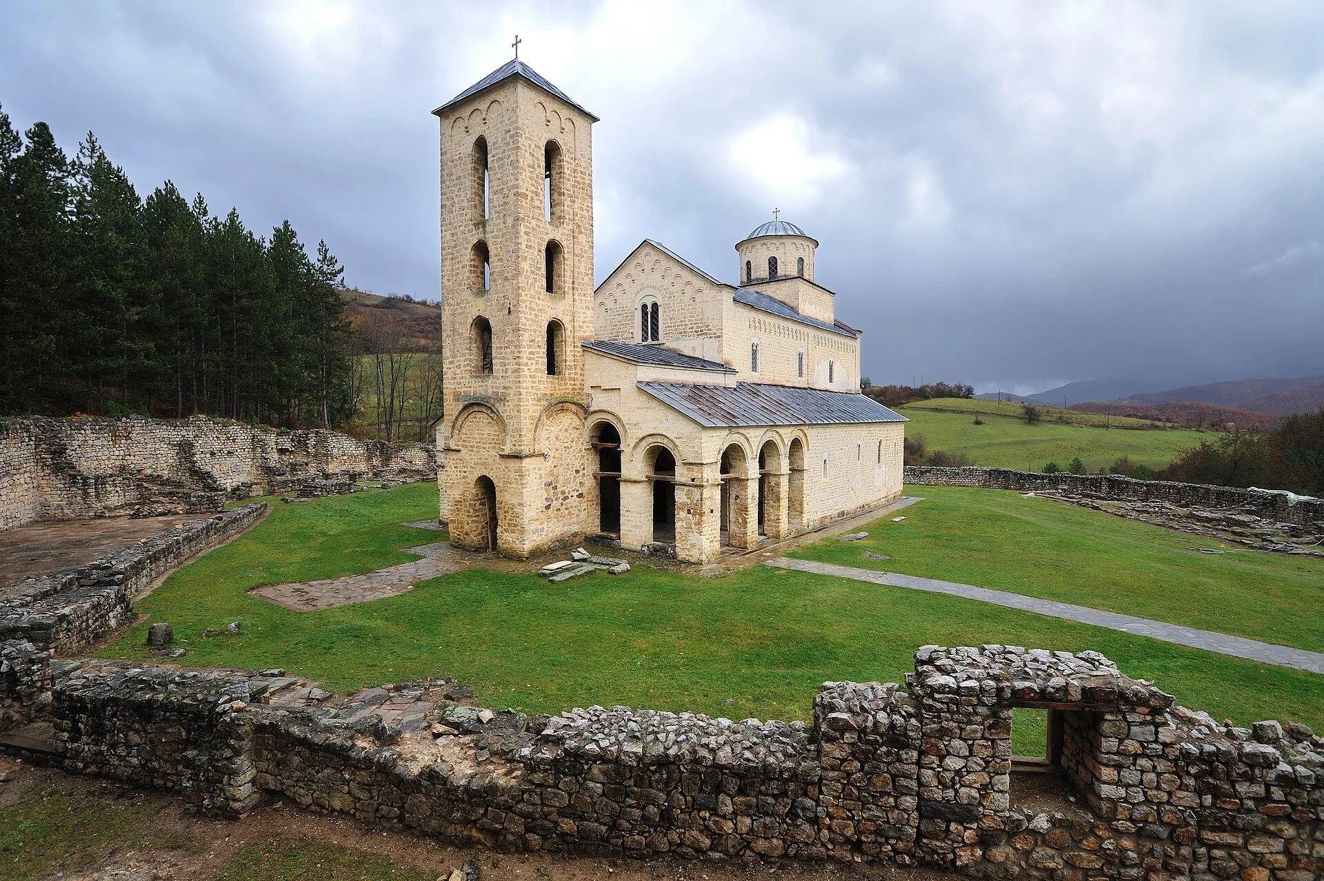 Außenansicht der Kirche des Klosters Sopoćani in bewaldeter Umgebung.