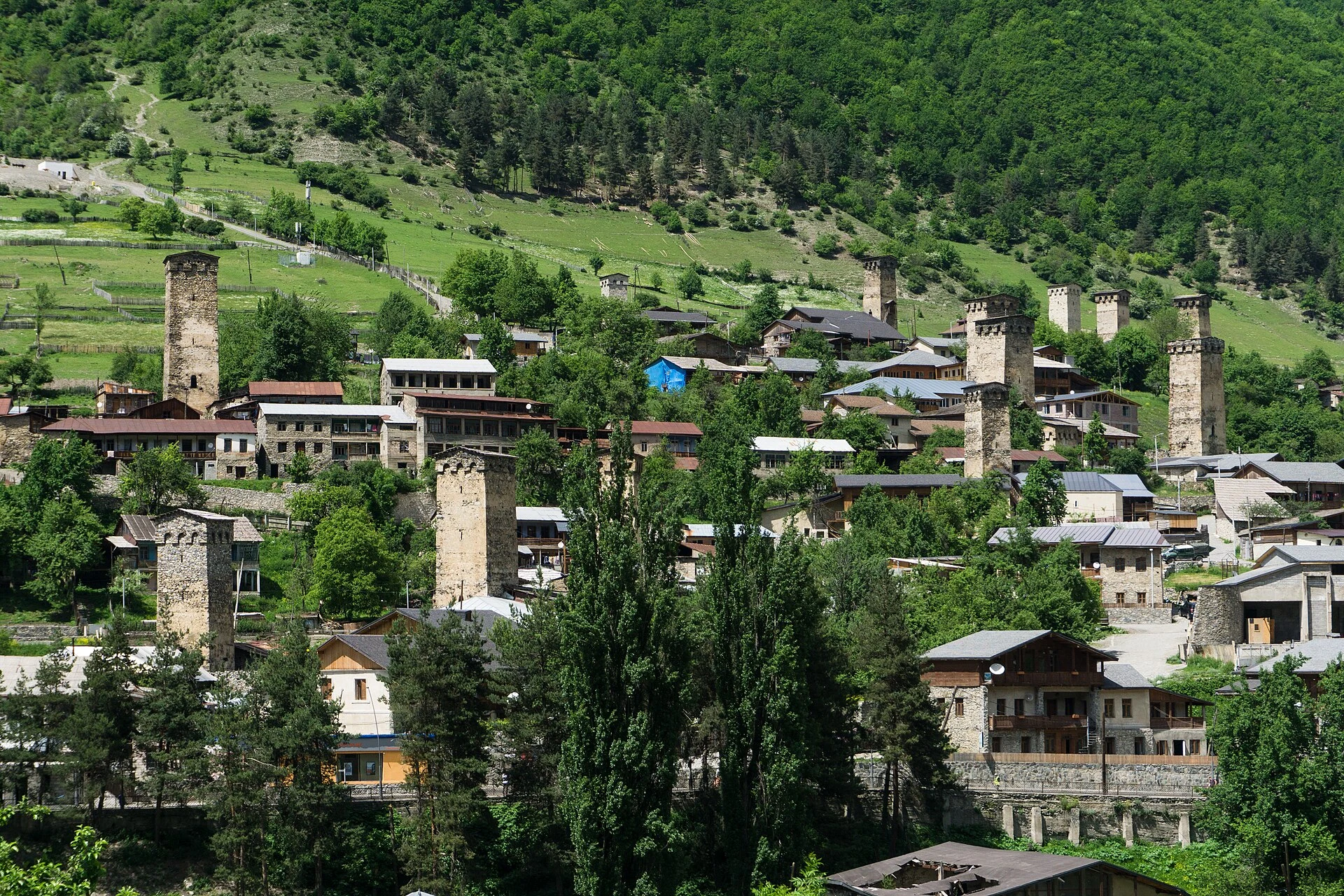 Tours svanes et maisons de pierre à Mestia, avec les montagnes du Caucase en arrière-plan.