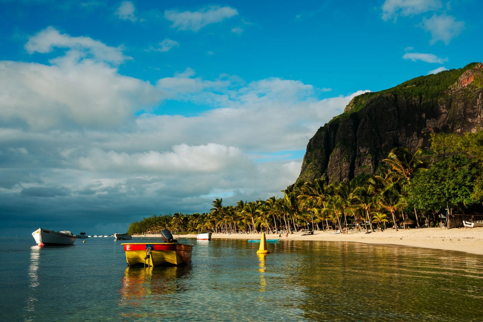 Strand mit Palmen und Booten bei Le Morne, Mauritius.