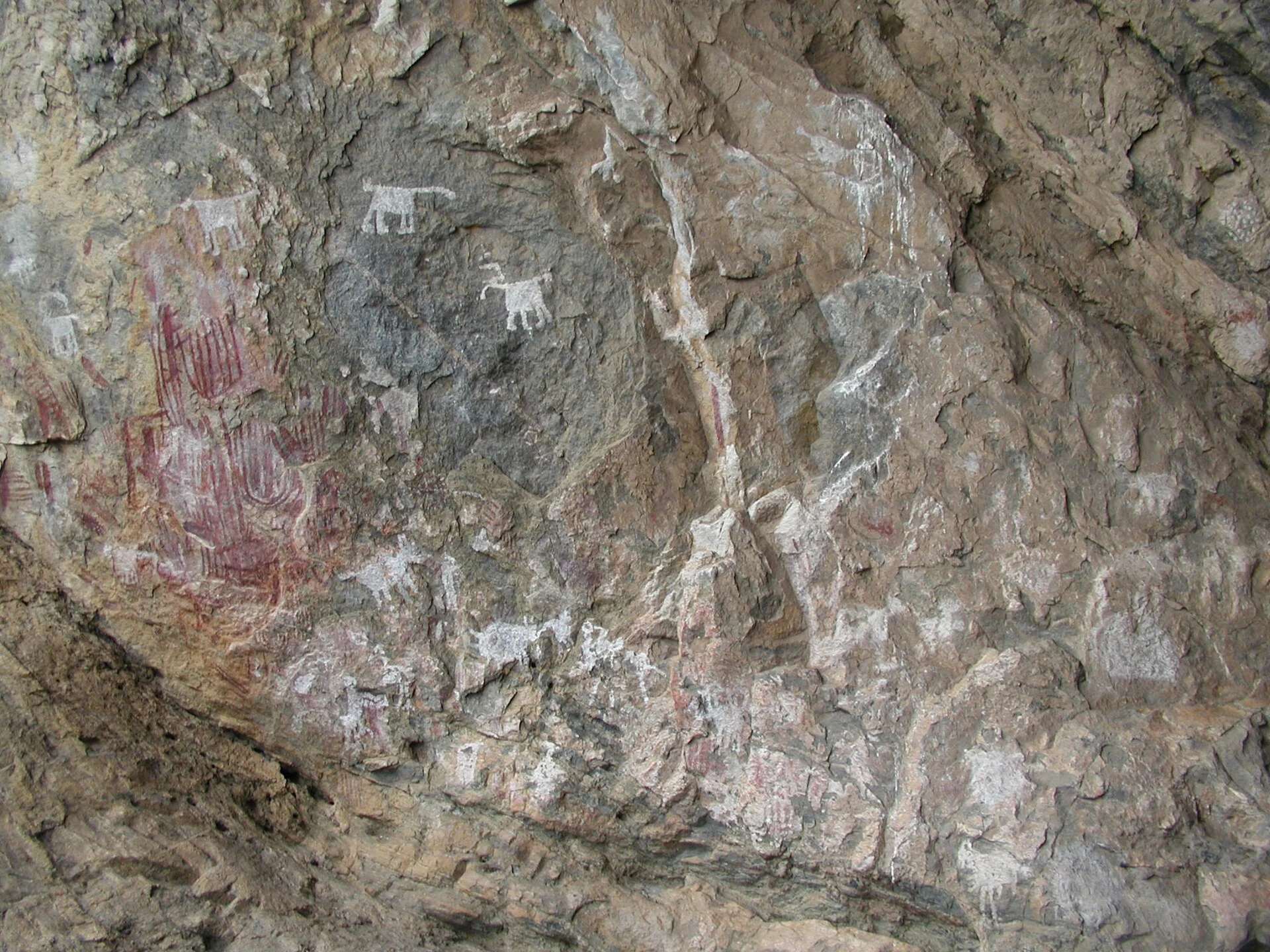 Detalhe respeitoso de pinturas rupestres vermelhas e brancas sobre granito em Chongoni.