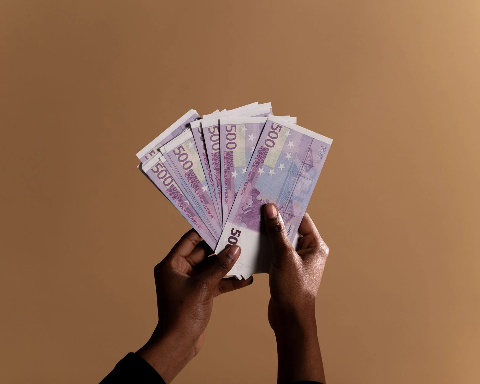 Euro banknotes and coins on a neutral surface.