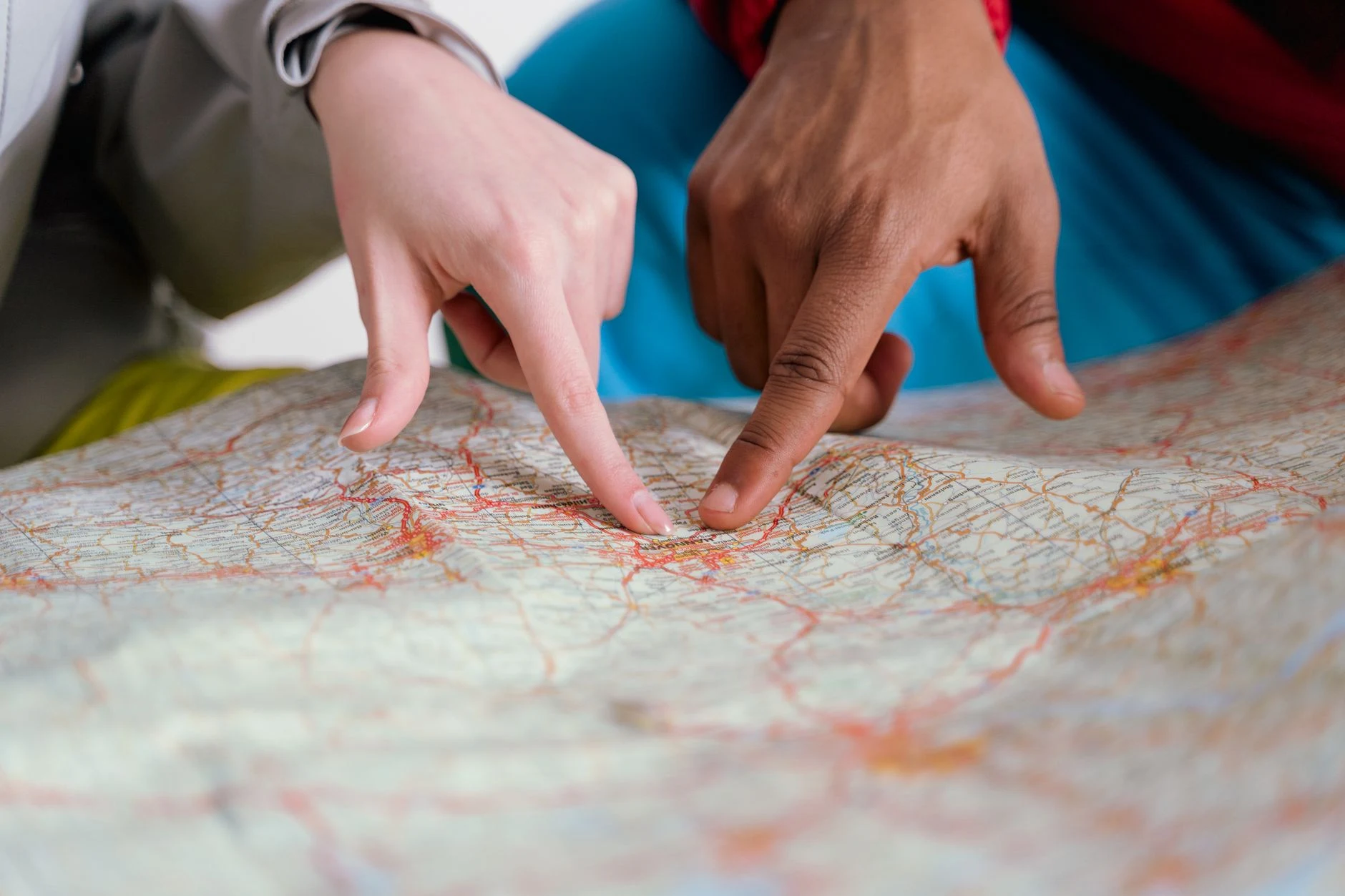 Mani consultano una cartina di viaggio senza un itinerario specifico.
